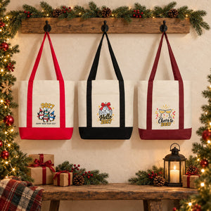 Three Christmas 2027 canvas tote bags with red, black and burgundy straps hanging on a rustic wall with penguin, Hello 2027 and Cheers to 2027 prints