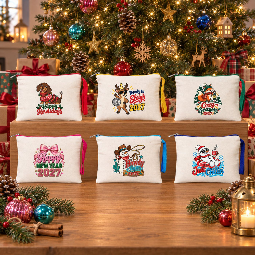 Six cream Christmas zipper clutch bags with red, yellow, green, fuchsia, turquoise and royal blue zippers and matching wrist straps on a wooden display in front of a decorated Christmas tree