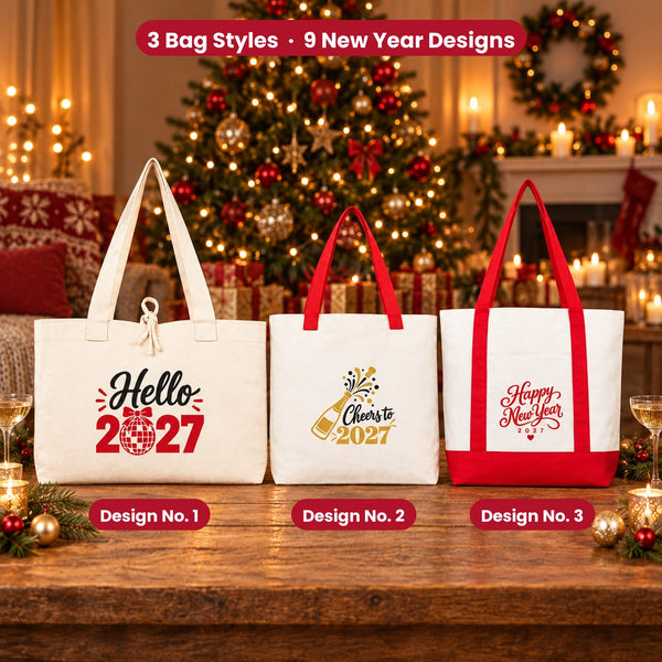Three natural canvas New Year 2027 tote bags with Design No. 1 Hello 2027, No. 2 Cheers to 2027 and No. 3 Happy New Year 2027 on a wooden table by a lit holiday tree
