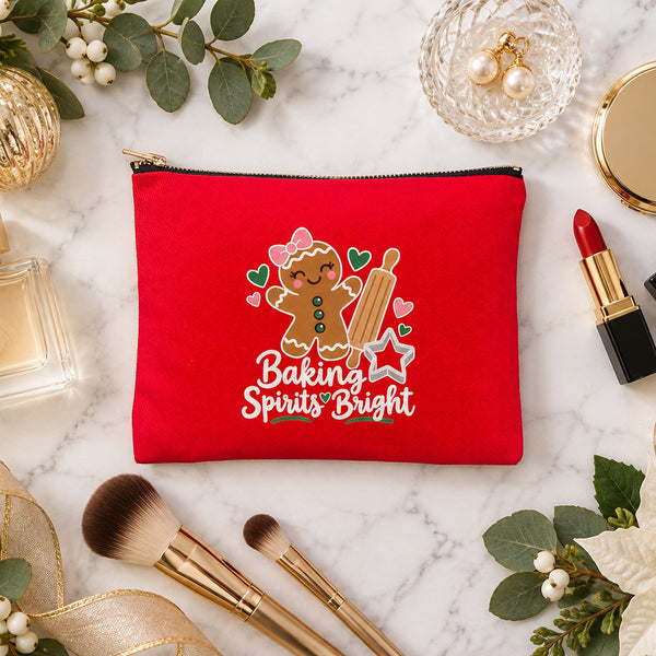 Red clutch makeup bag with a Baking Spirits Bright gingerbread print on a marble vanity with perfume, lipstick, makeup brushes and gold ornaments