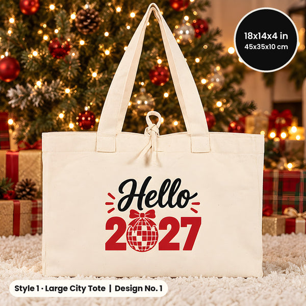 Natural Large City canvas tote bag 18x14x4 inch printed Hello 2027 on a white rug in front of a lit holiday tree and wrapped gifts