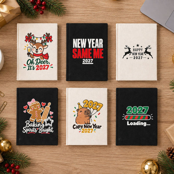 Six canvas notebooks in natural and black with different Christmas and New Year 2027 designs laid out as bulk holiday gifts for a team