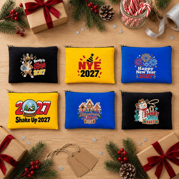 Six black, yellow and royal blue clutch bags with different New Year 2027 designs laid out as bulk holiday gifts