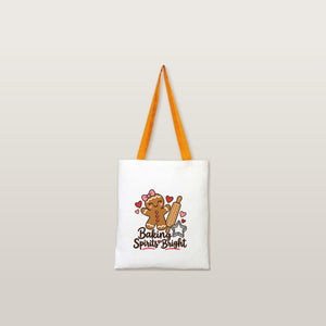 Mustard handle natural cotton tote bag with a Baking Spirits Bright gingerbread print on a plain studio background