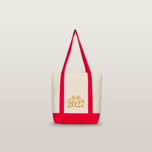 Studio photo of the red strap canvas tote bag with a gold bow 2027 print