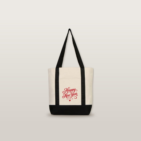 Studio photo of the black strap canvas tote bag with a red Happy New Year 2027 script print