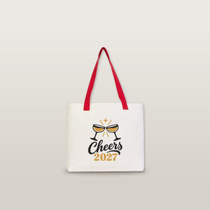 Studio photo of a large canvas tote bag with red knitted straps and a Cheers 2027 champagne print