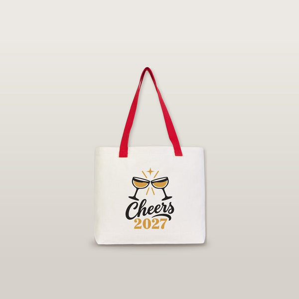 Studio photo of a large canvas tote bag with red knitted straps and a Cheers 2027 champagne print