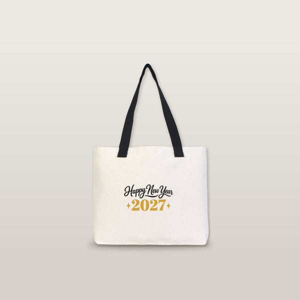 Studio photo of a large canvas tote bag with black knitted straps and a Happy New Year 2027 gold print