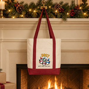 Burgundy strap canvas tote bag with a penguin Happy New Year 2027 print hanging from a fireplace mantel like a big gift stocking
