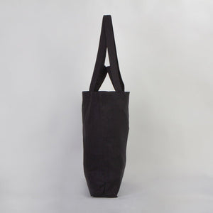 Black tote bag on a light gray background