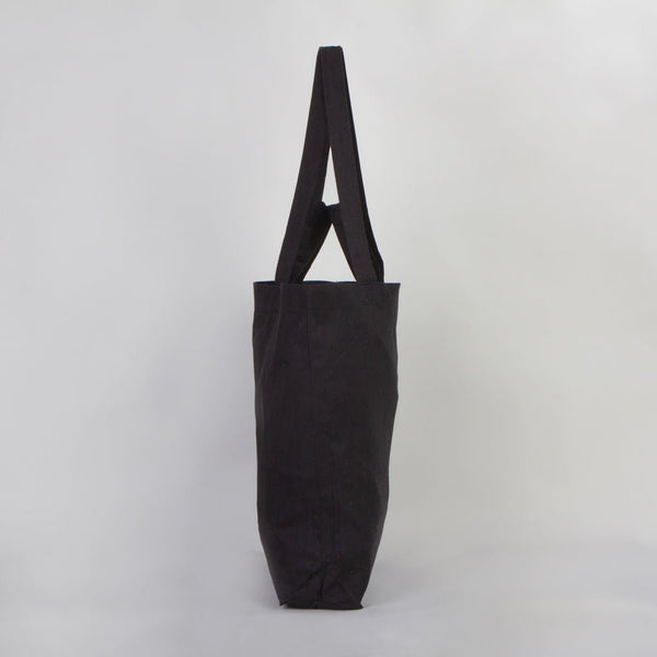 Black tote bag on a light gray background
