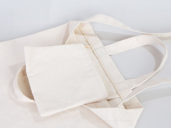 Beige tote bag with a square pouch on a light gray background