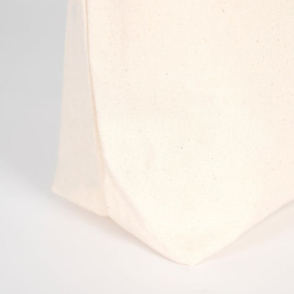 Close-up of a textured white fabric corner on a light gray background