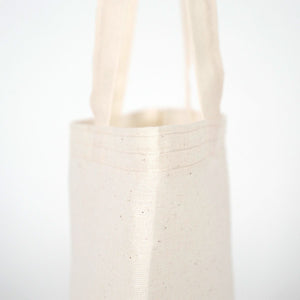 White woven basket with handles on a light gray background