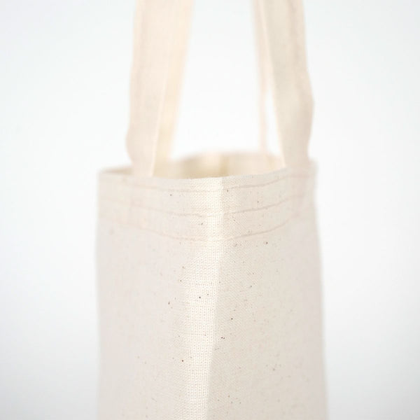 White woven basket with handles on a light gray background