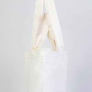 White tote bag with a handle on a light gray background