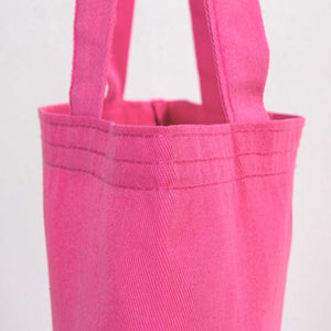 Close-up of a pink tote bag with handles on a light gray background