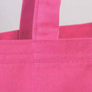 Close-up of a pink tote bag with handles on a light gray background