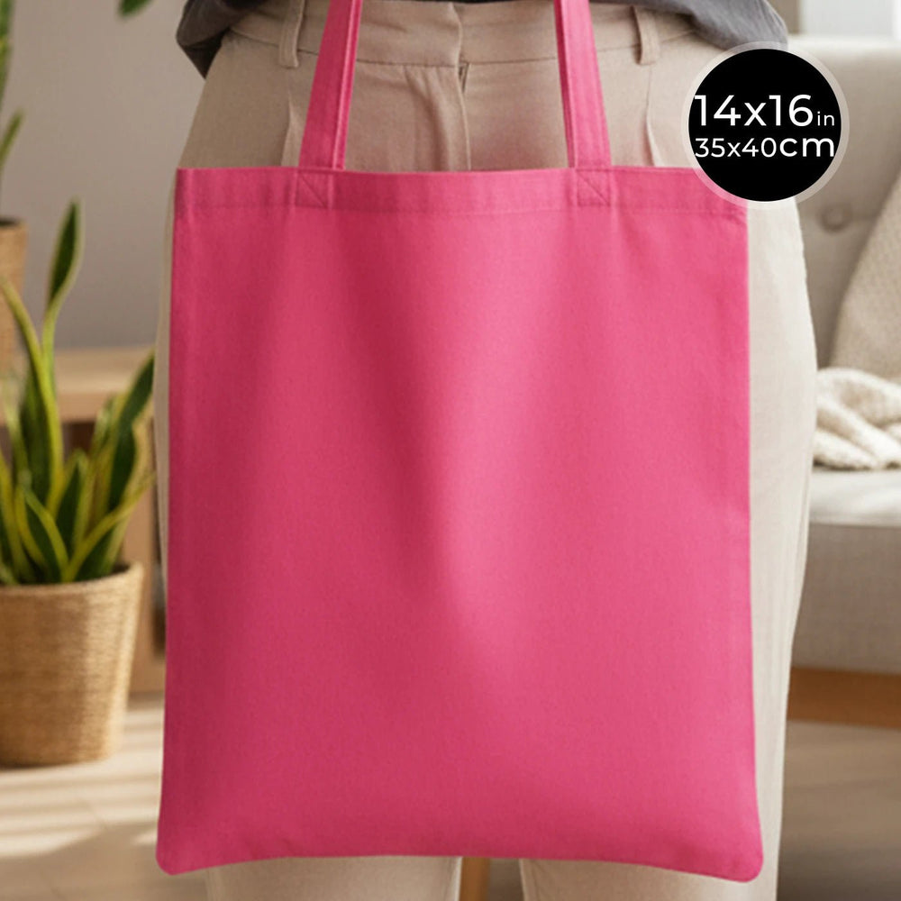 Pink tote bag held by a person with dimensions displayed