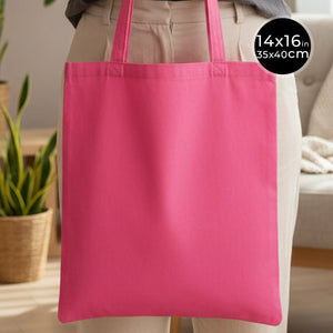 Pink tote bag held by a person with dimensions displayed