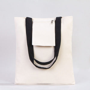 White tote bag with black handles on a light gray background