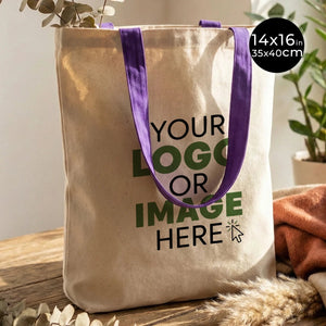 Beige tote bag with purple handles on a wooden surface, customizable with 'Your Logo or Image Here'.