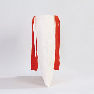 White pillow with red straps on a light gray background