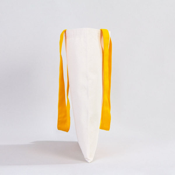 White pillow with yellow straps on a light gray background