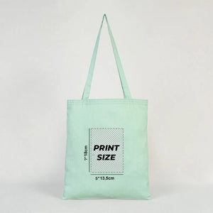 Mint green tote bag with print size information on a light gray background