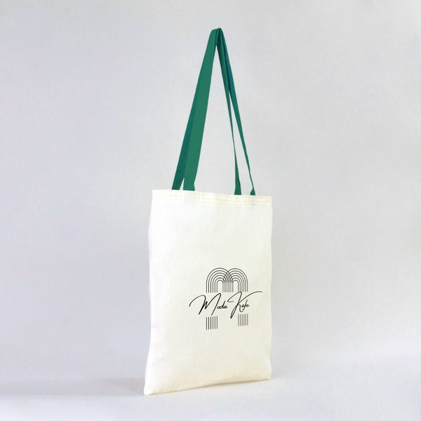 White tote bag with green straps and a logo on a white background