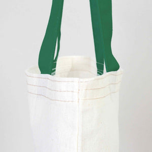 White tote bag with green handles on a white background