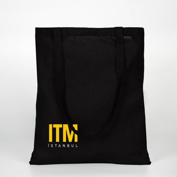 Black tote bag with yellow 'ITM Istanbul' logo on a white background