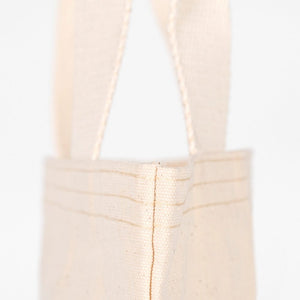 Close-up of a beige tote bag with handles on a white background