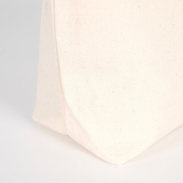 Close-up of a textured white fabric corner on a light gray background