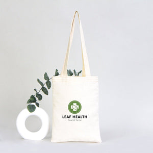 Tote bag with 'Leaf Health' logo and eucalyptus branch on a light gray background