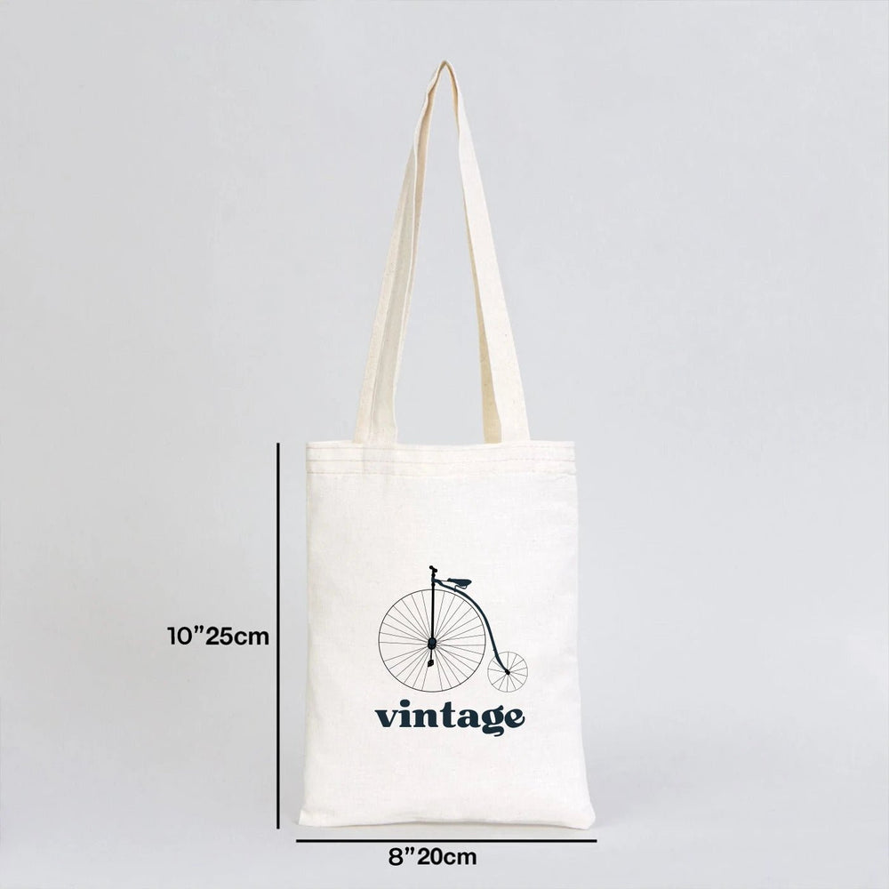 Beige tote bag with customizable text on a wooden surface