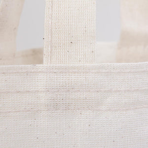 Close-up of a textured beige fabric bag with a white background
