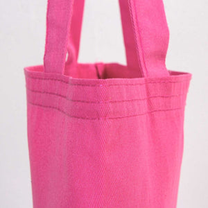Close-up of a pink tote bag with handles on a light gray background