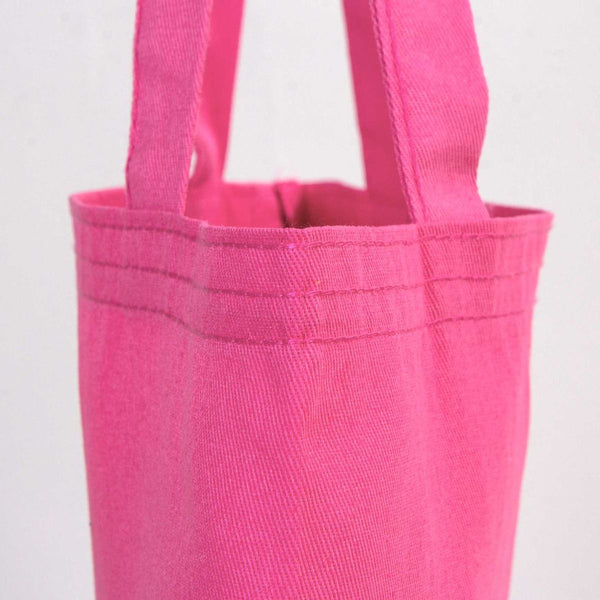 Close-up of a pink tote bag with handles on a light gray background