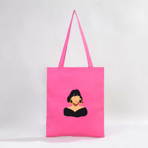 Pink tote bag with a graphic of a woman's face on a white background