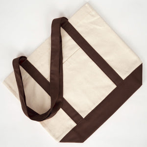 Plat neergelegde canvas tas met donkerbruine hengsels - Pamusan.nl