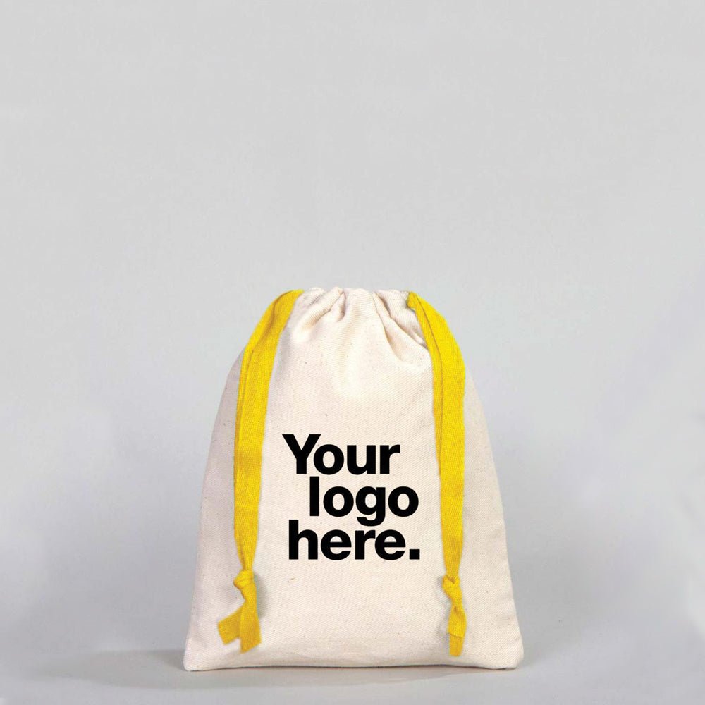 Canvas drawstring bag with yellow drawstrings and customizable text area on a gray background