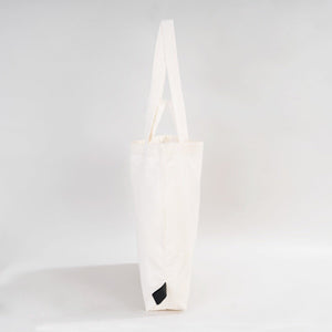White tote bag with a black logo on a light gray background