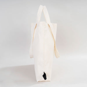 White tote bag with a black paw print on a light gray background