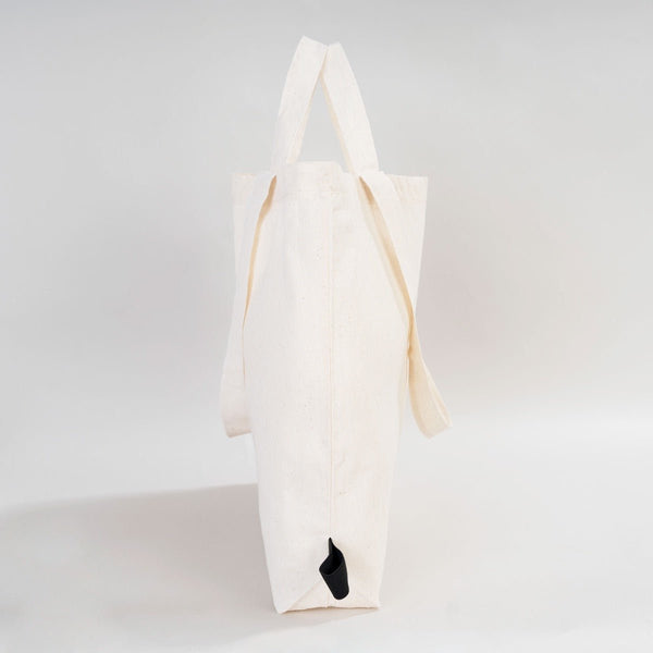 White tote bag with a black paw print on a light gray background