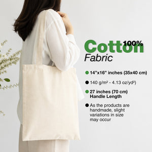 Person holding a beige tote bag with product details on a light gray background