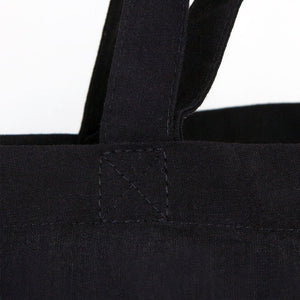 Close-up of a black tote bag with handles on a white background