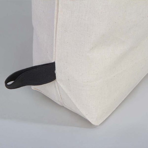 Close-up of a beige cushion with a black strap on a light gray background